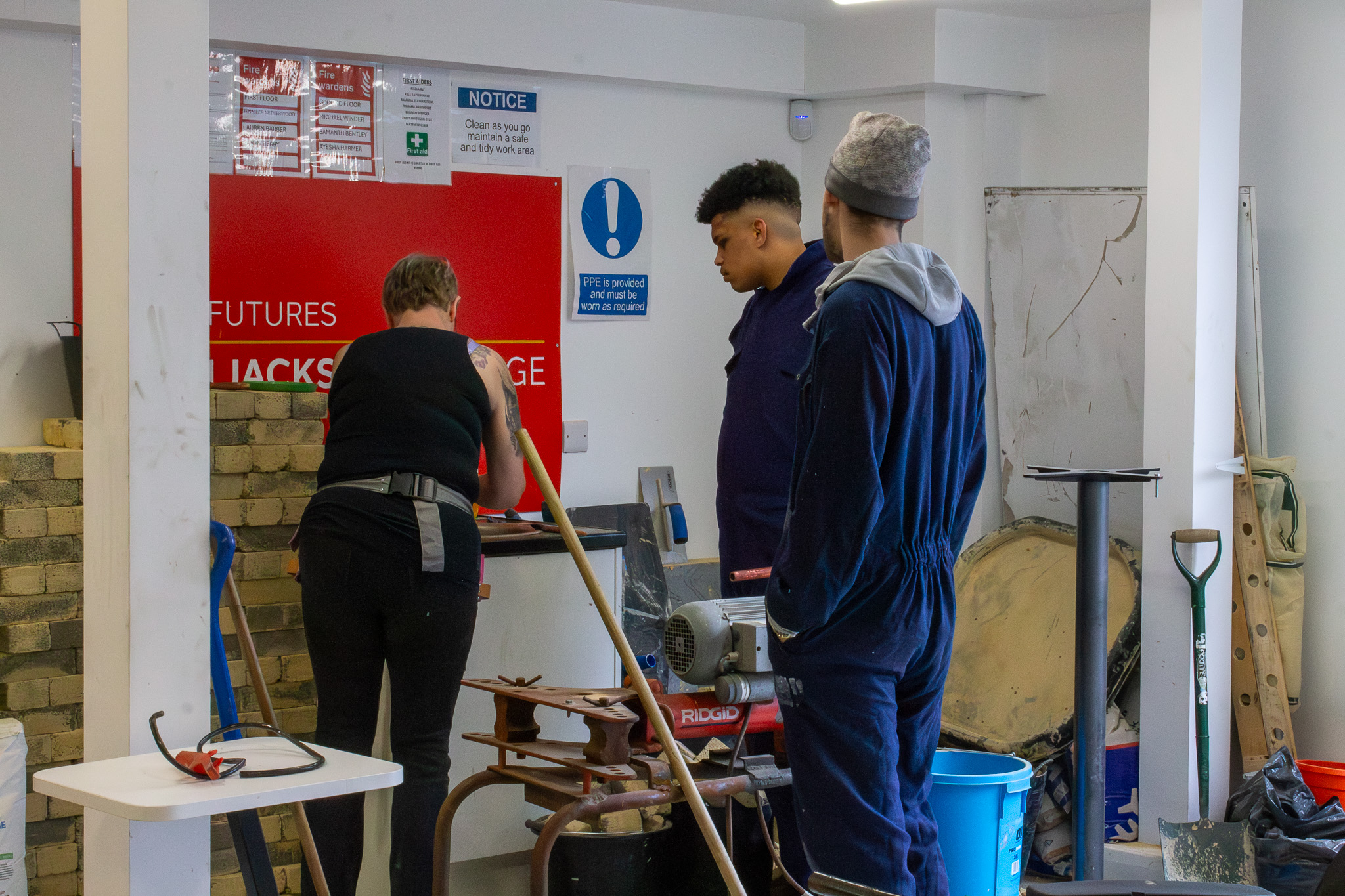 students with teacher in construction workshop