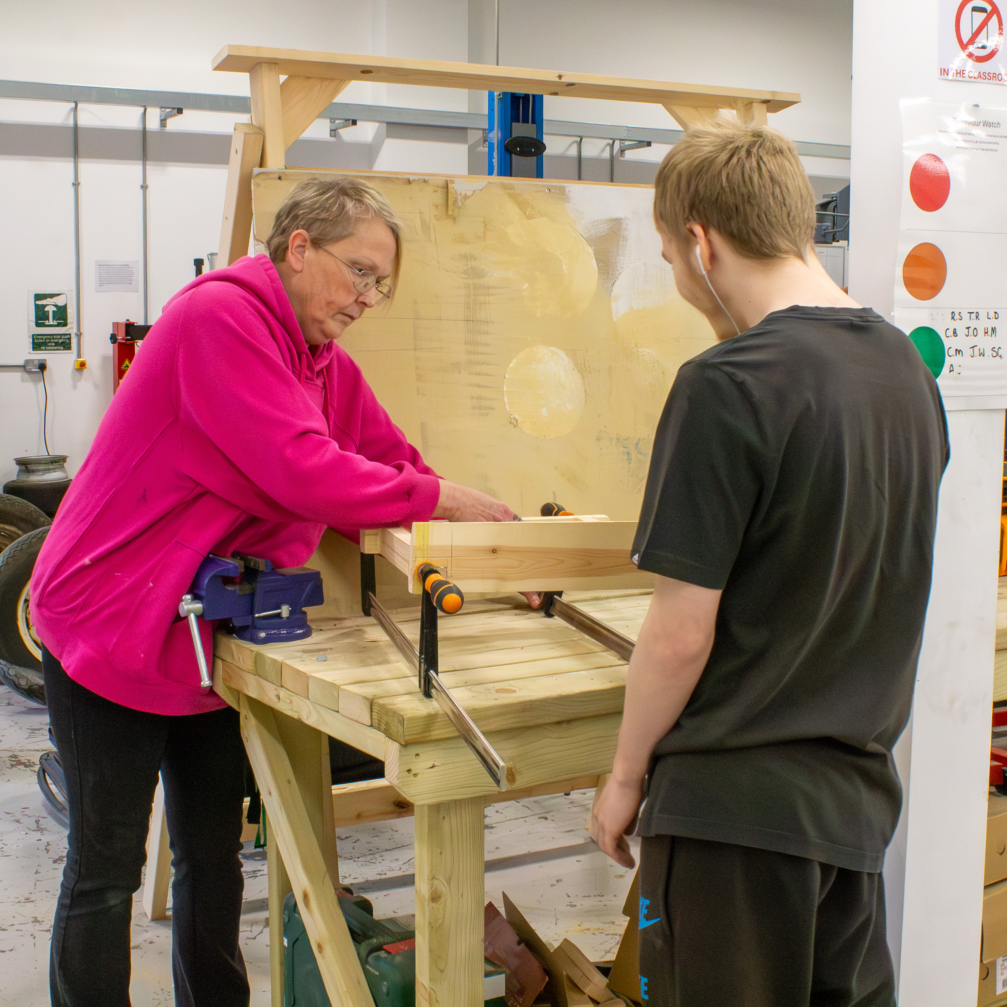 student with teacher in mechanics workshop